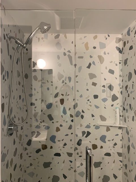 The playful terrazzo tiling in the shower of the main bath.
